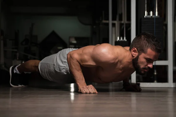 Modèle faisant des soulèvements de presse dans le gymnase — Photo