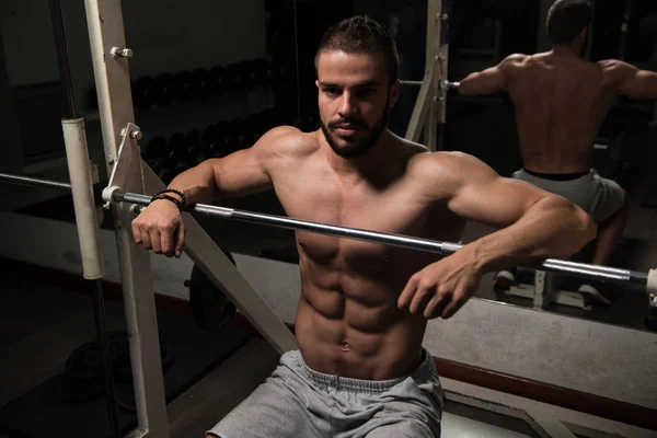 Muskulöses Modell ruht sich nach dem Training auf Bank aus — Stockfoto