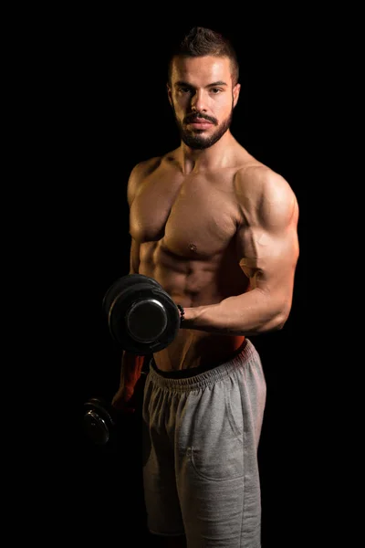 Idrottsman tränar Biceps på svart bakgrund — Stockfoto