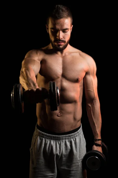 Atleta ejercitando el hombro sobre fondo negro — Foto de Stock