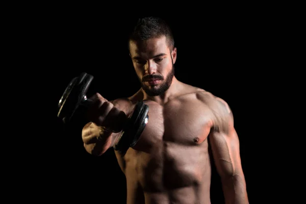 Modelo Exercício ombros com halteres em fundo preto — Fotografia de Stock