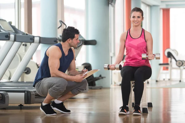 Osobisty trener pomaga kobieta na Biceps ćwiczenia — Zdjęcie stockowe