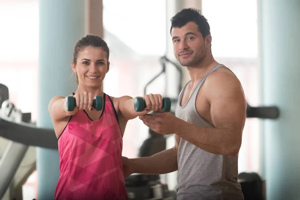 Palestra allenatore aiutare donna sulla spalla esercizio fisico — Foto Stock