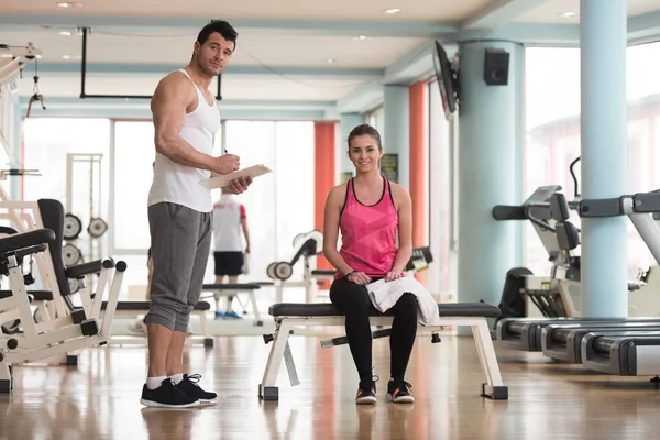 Trainer prende appunti mentre la donna seduta e riposante — Foto Stock