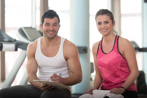 Trainer prende appunti mentre la donna seduta e riposante — Foto Stock