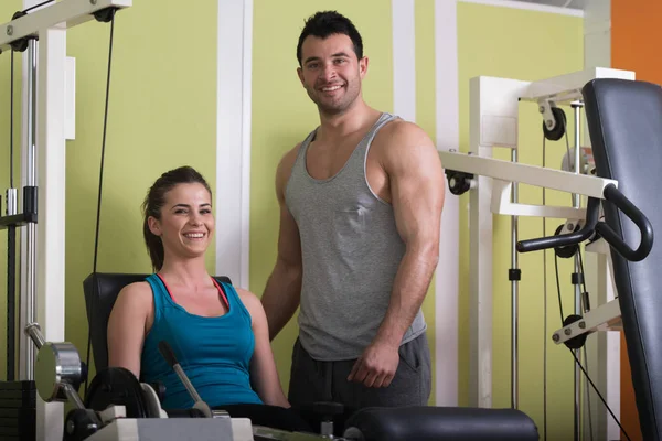 Entrenador de gimnasio ayudando a la mujer en las piernas — Foto de Stock