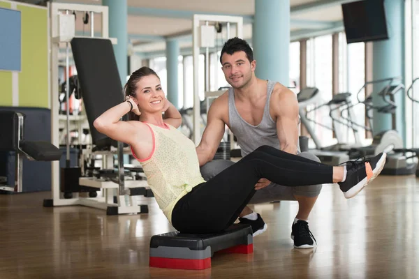 Fitnesstrainerin hilft Frau bei Busen-Bauchmuskeltraining — Stockfoto
