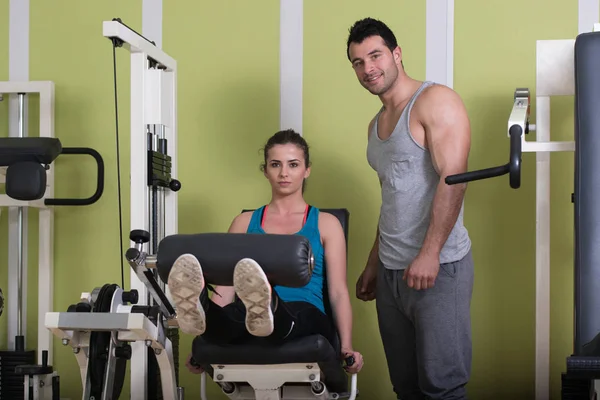 Palestra allenatore aiutare donna su gambe — Foto Stock