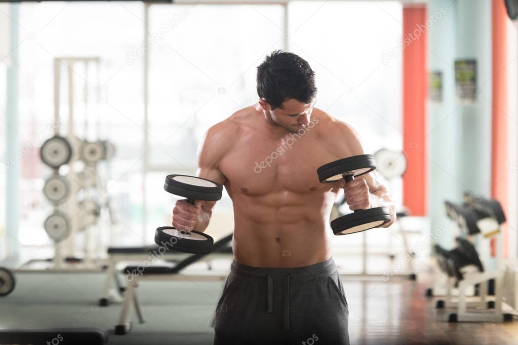 Athlete Exercising Biceps With Dumbbells