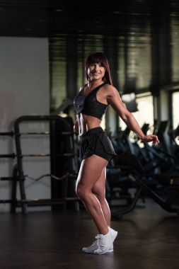 Çekici kaslı kadın içinde jimnastik salonu kas esneme