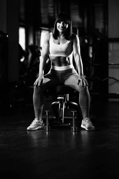 Mujer descansando en el banco en el gimnasio — Foto de Stock