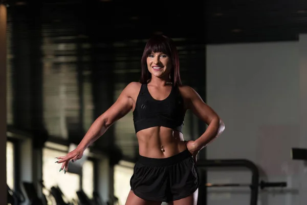Attraktiv muskulös kvinna flexar muskler i gymmet — Stockfoto