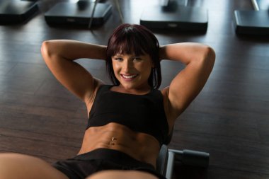 Genç kadının spor salonunda karın egzersiz yapması