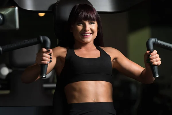 Kvinna som tränar bröstet i gymmet — Stockfoto