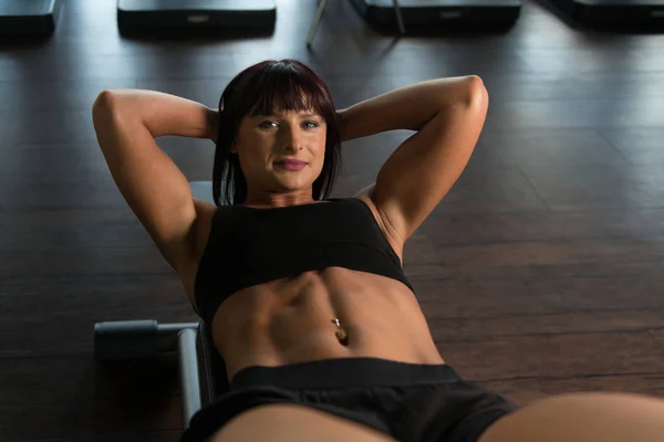 Fitness kvinna gör buken övning i gymmet — Stockfoto