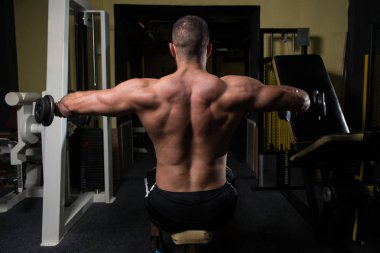 Bir spor salonunda egzersiz Dumbbells ile omuz