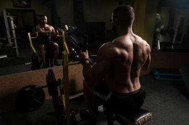 Kaslı adam arka için ağır egzersiz yaparak