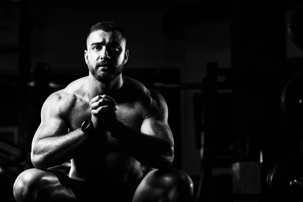 Jeune homme attrayant reposant dans la salle de gym après l'exercice — Photo