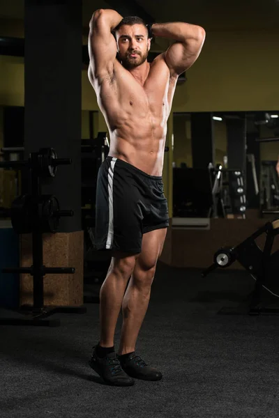 Όμορφος μυώδης άνδρας λύγισμα των μυών στο γυμναστήριο — Φωτογραφία Αρχείου