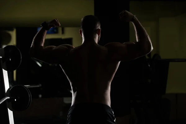 Siluet Muscular Hombre Flexing Músculos En Gimnasio —  Fotos de Stock