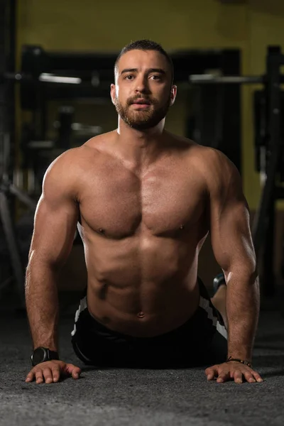 De rek van de Man van de fitness op de verdieping — Stockfoto