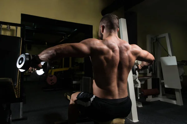 Hombre con sombrillas haciendo ejercicio en los hombros —  Fotos de Stock