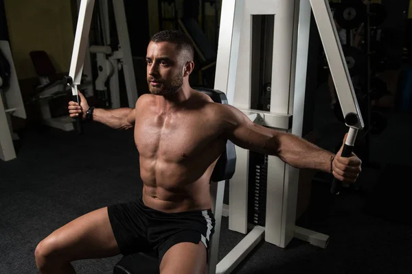 Bodybuilder trainiert Brust an Maschine — Stockfoto