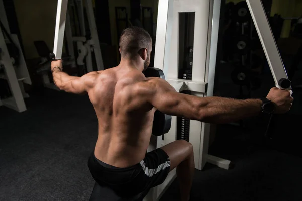 Culturista haciendo ejercicio de vuelta en el gimnasio —  Fotos de Stock