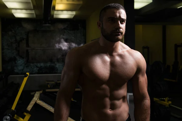 Attraktiver junger Mann ruht sich nach dem Sport im Fitnessstudio aus — Stockfoto