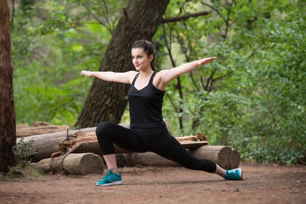 Deportista estirando brazo en el bosque — Foto de Stock