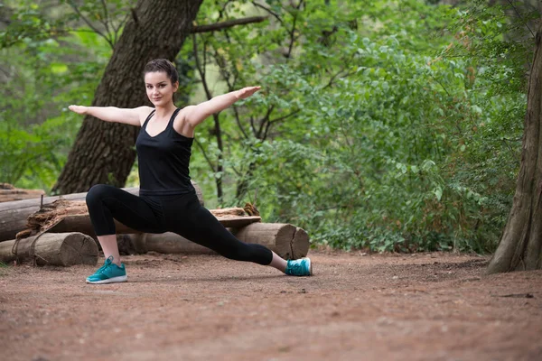 Fitness Woman Stretching in Wooded Forest Area — стоковое фото