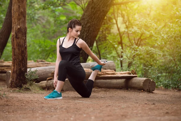 Woman Runner Stretching Leg in a City Park — Stock Photo, Image