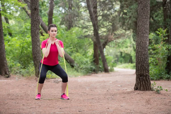 Woman Training With Exercise Band at Park