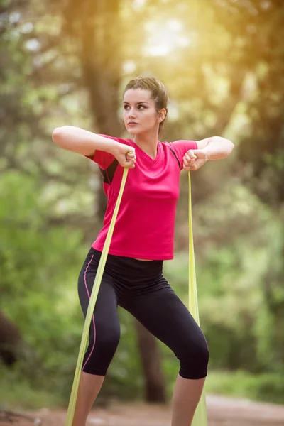 Femme faisant de l'exercice avec bande de résistance et étirement — Photo