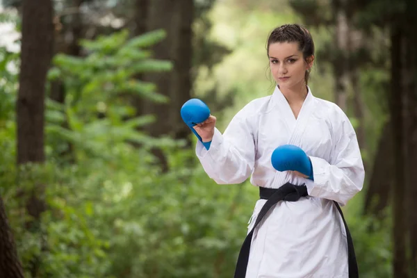 Donna in bianco formazione karate a parco — Foto Stock