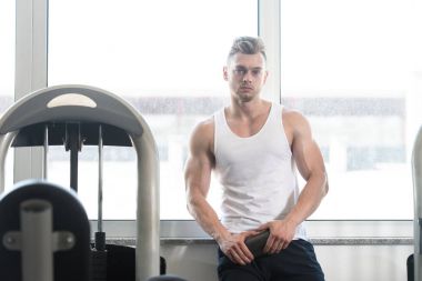 Genç adam şişeden su içiyor.