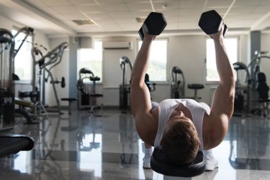 Spor salonunda Dumbbells ile göğüs egzersiz vücut geliştirmeci