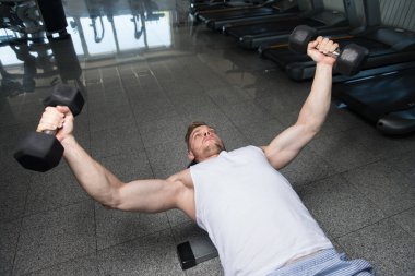 Genç adam için göğüs Dumbbells ile egzersiz yaparak