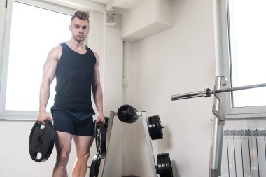 Ağırlıkları elinde tutan vücut geliştirmeci