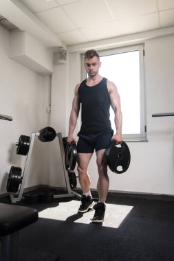 Ağırlıkları elinde tutan adam uygun