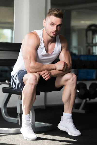 Male Resting On Bench In Fitness Center