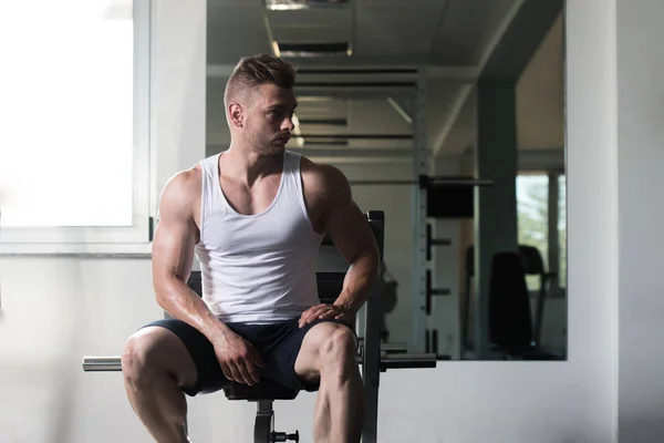 Uomo che riposa sul banco nel centro fitness — Foto Stock