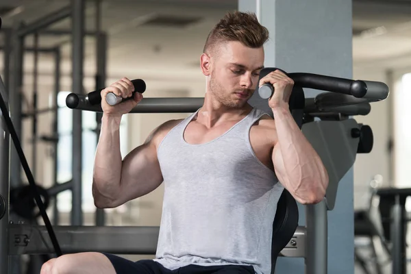 Bodybuilder Exercising Shoulders On Machine — Stock Photo, Image