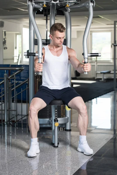 Ung Man utövar bröstet i gymmet — Stockfoto