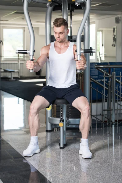 Ung Man utövar bröstet i gymmet — Stockfoto