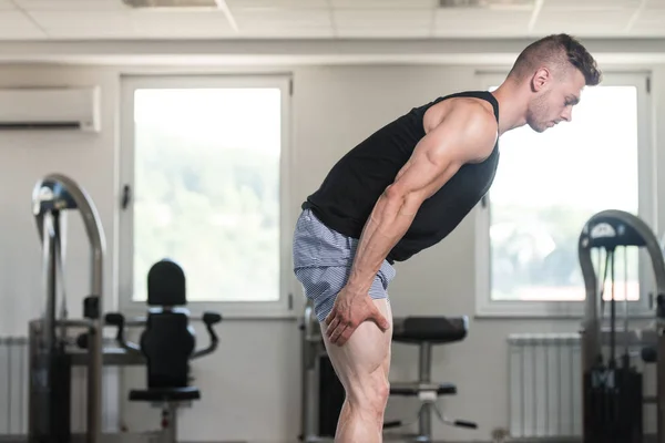 Friska unga mannen sträckor i gymmet — Stockfoto