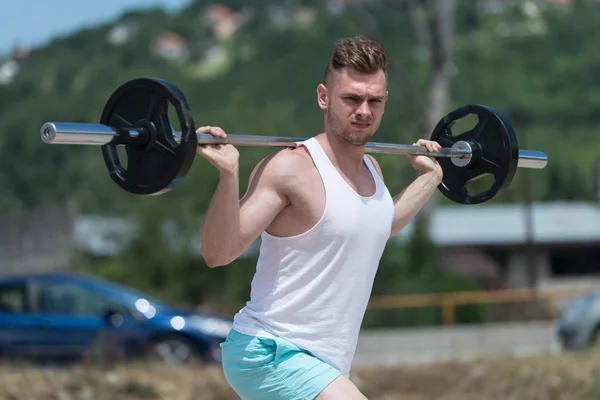 Cvičení nohou s činka v přírodě — Stock fotografie