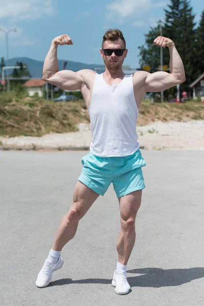 Muskulöser Mann lässt Muskeln im Freien spielen — Stockfoto