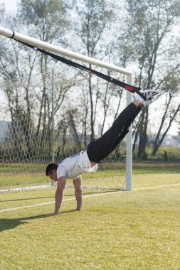 Genç adam trx askıları egzersiz Park yapmak
