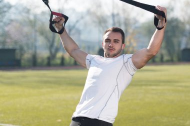 Trx Fitness askıları ile çekici bir adam eğitim